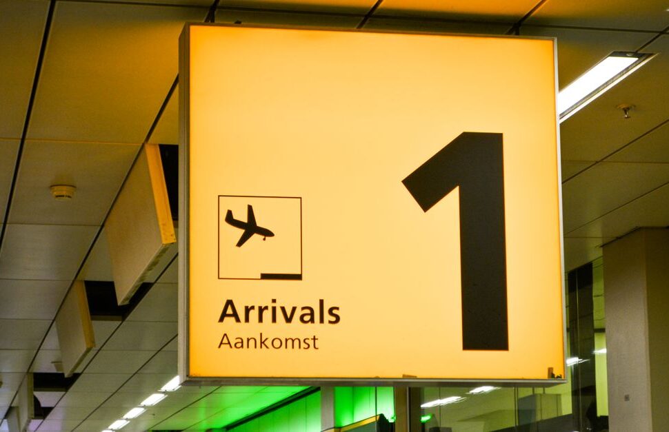 Bright yellow arrivals sign with a large number 1, an airplane icon, and the words 'Arrivals' and 'Aankomst' (Dutch for arrivals).