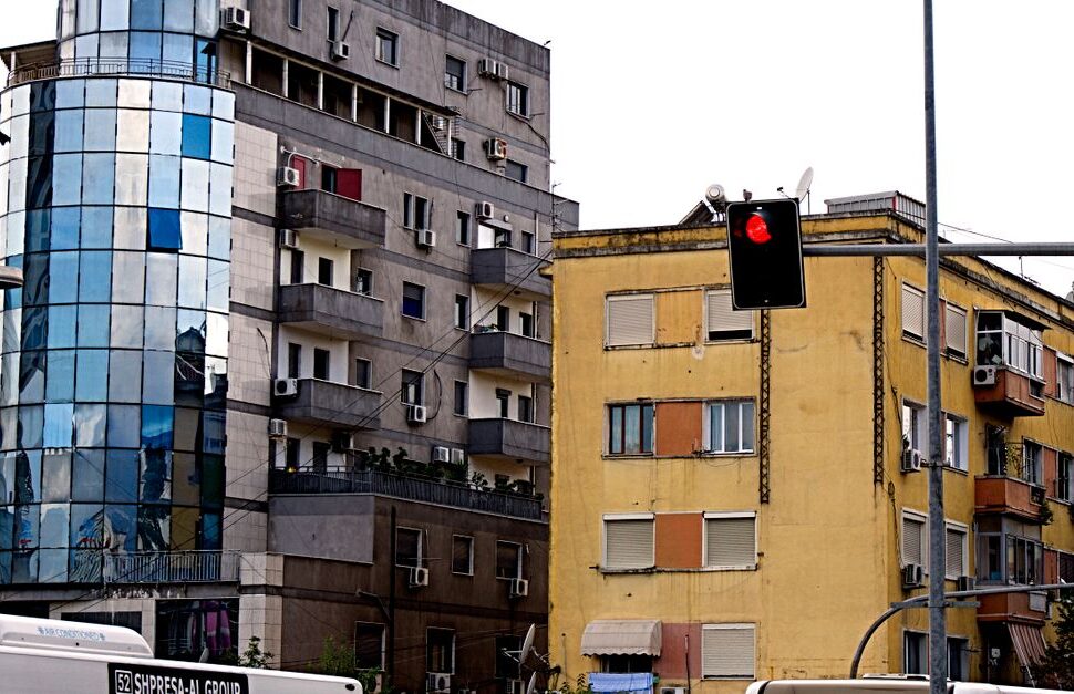 A vibrant cityscape of Tirana showcasing modern buildings and traffic activity.