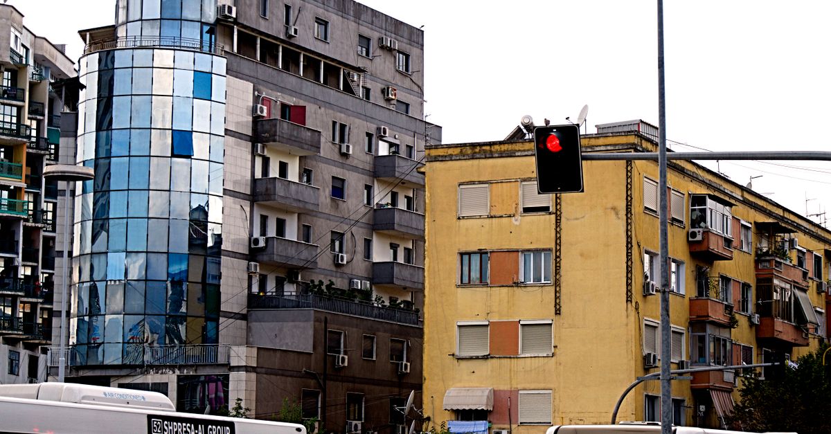 A vibrant cityscape of Tirana showcasing modern buildings and traffic activity.