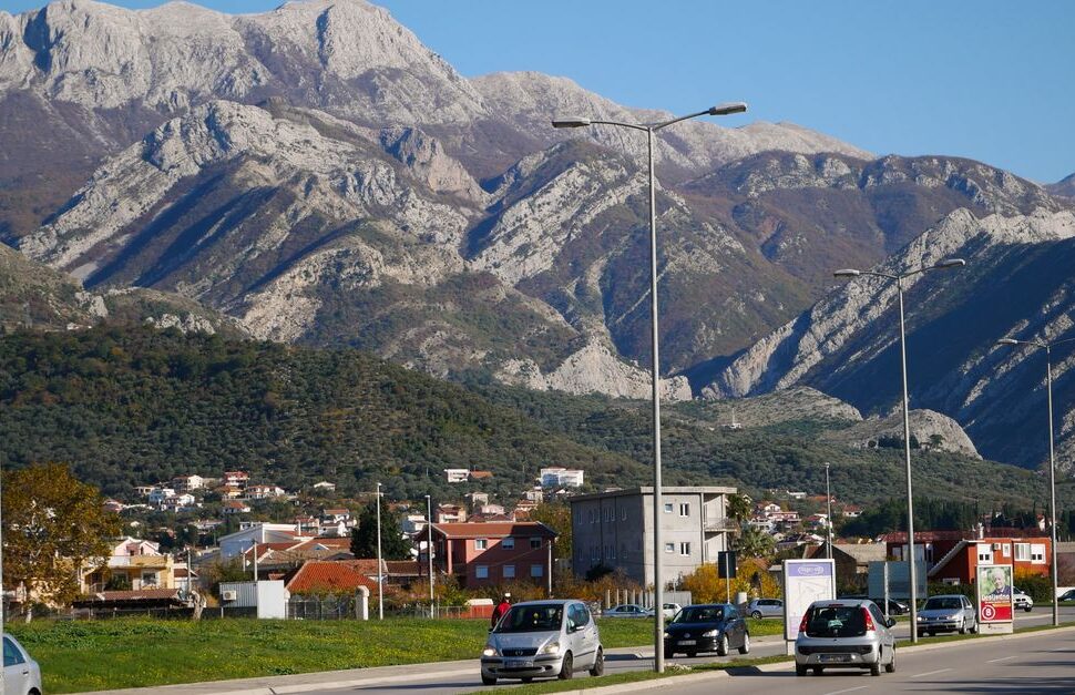 Discover the stunning landscape of Bar, Montenegro with a scenic road lined by majestic mountains.